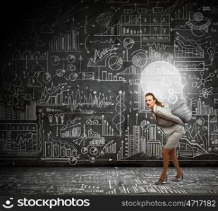 Bright idea. Young businesswoman carrying light bulb on back