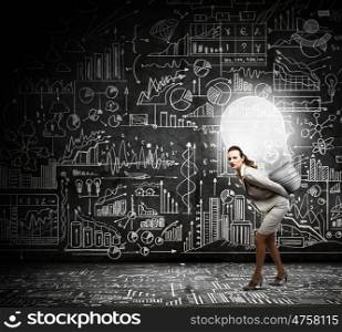 Bright idea. Young businesswoman carrying light bulb on back