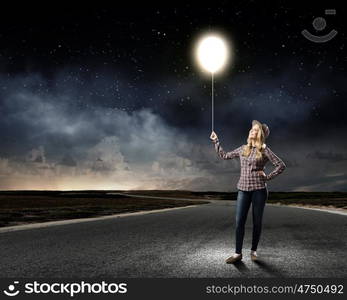 Bright idea. Young woman in casual holding bulb balloon