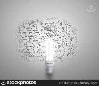 Bright ideas for business. Glowing light bulb on wall with sketches strategy plan