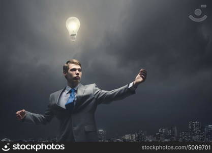 Bright ideas. Young confident businessman and light bulb above his head