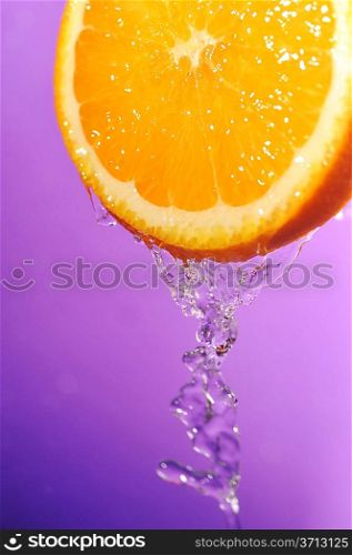 bright juicy orange and splashes on violet background