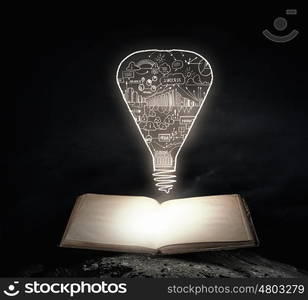 Bright light of education. Old opened book with business strategy sketches