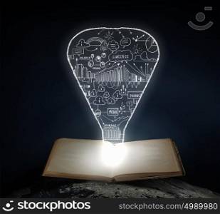 Bright light of education. Old opened book with business strategy sketches