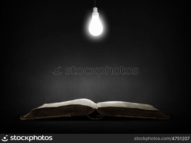 Bright light of education. Opened book and glowing light bulb above pages