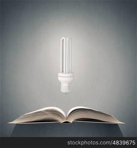 Bright light of education. Opened book and glowing light bulb above pages