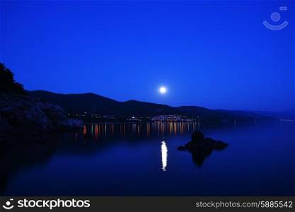 bright moon illuminates sea shore. Night on resort