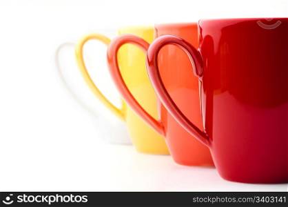 Bright mugs. Perspective row of bright colorful mugs, red, orange, yellow and white, on a white background