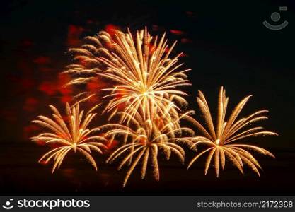 Bright multi-colored fireworks on a festive night. Beautiful color flashes in the dark sky for a holiday.. Bright fireworks on a festive night. Colored lights in the dark sky for a holiday.