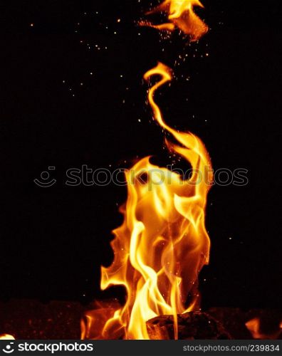 bright orange and yellow flames with sparks, close up