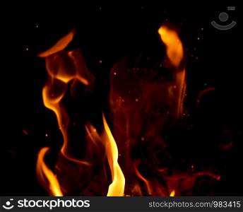 bright orange and yellow flames with sparks, close up, black background