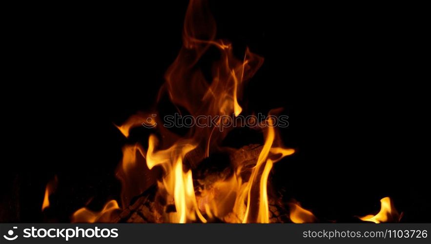 bright orange and yellow flames with sparks on black background, close up