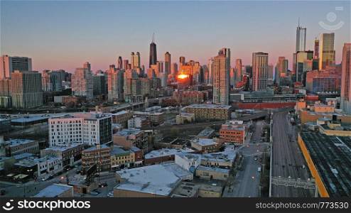 Bright orange light reflects off the buildings in downtown Chicago at sunset