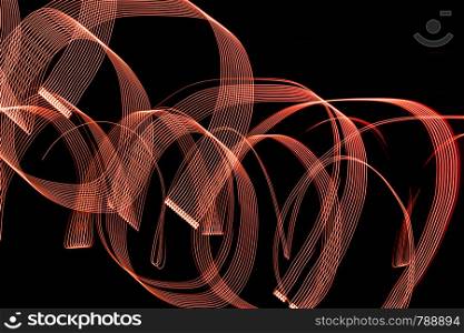 Bright orange spiral patterns from light strips on a black background. Bright spiral patterns from light strips on a black background