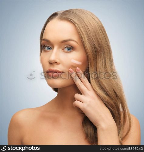 bright picture of beautiful woman applying foundation.