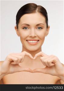 bright picture of beautiful woman showing heart shape