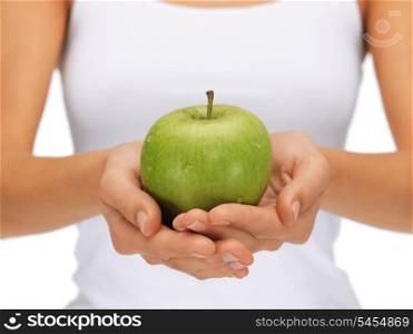 bright picture of female hands with green apple