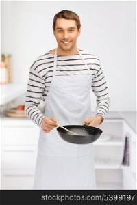 bright picture of handsome man with pan at kitchen