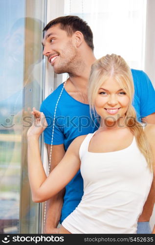 bright picture of happy couple at the window (focus on man)