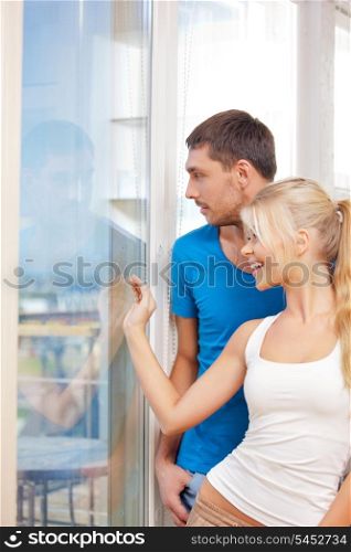 bright picture of happy couple at the window (focus on man)