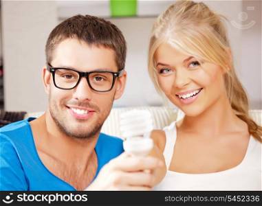 bright picture of happy couple holding energy saving bulb