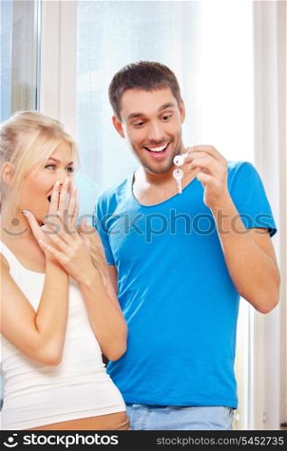 bright picture of happy couple with keys (focus on man)