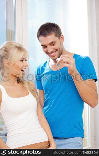 bright picture of happy couple with keys (focus on man)