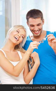 bright picture of happy couple with keys (focus on woman)