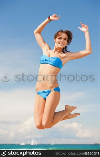 bright picture of happy jumping woman on the beach.