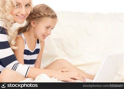 bright picture of happy mother and child with laptop computer (focus on girl)&#xA;