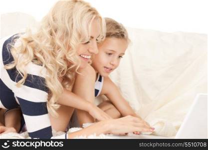 bright picture of happy mother and child with laptop computer (focus on woman)