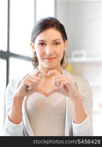 bright picture of happy woman making heart gesture
