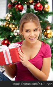 bright picture of happy woman with gift box and christmas tree