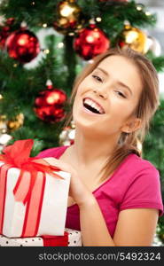 bright picture of happy woman with gift box and christmas tree