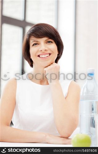 bright picture of lovely housewife with green apple and bottle of water