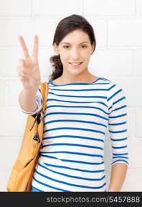 bright picture of lovely teenage girl showing victory sign