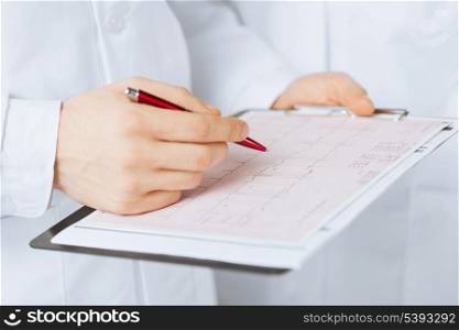 bright picture of male doctor hands holding cardiogram