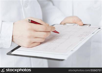 bright picture of male doctor hands holding cardiogram