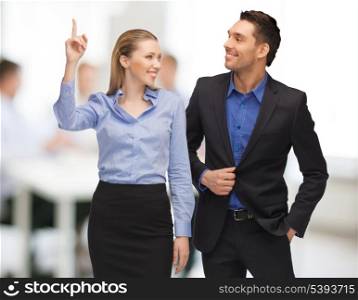 bright picture of man and woman pointing finger in office