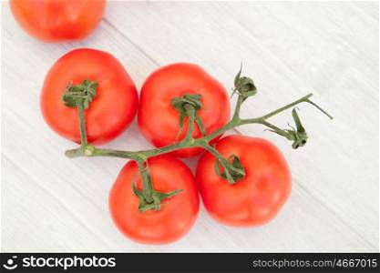 Bright picture of vine tomatoes on a white wooden background