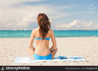 bright picture of woman sitting on a towel.