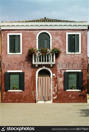 Bright red color house in Burano, Venice
