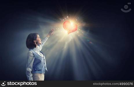 Bright red heart love . Young businesswoman blinded with light of heart going from above