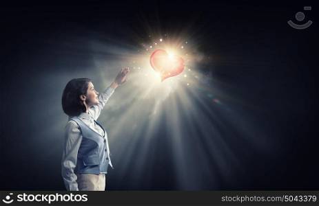 Bright red heart love . Young businesswoman blinded with light of heart going from above