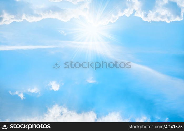 Bright shining sun and sunbeams, white clouds and blue sky for nature background