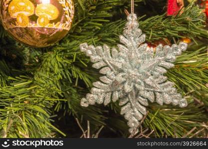 bright silver six point star decoration on green christmas tree