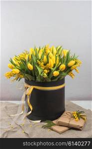Bright spring bouquet of tulips and mimosa flowers. Mother&amp;#39;s Day or Easter theme.