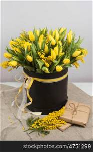 Bright spring bouquet of tulips and mimosa flowers. Mother's Day or Easter theme.