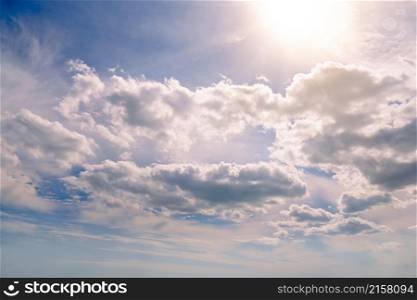 Bright summer sun in blue sky with white clouds.