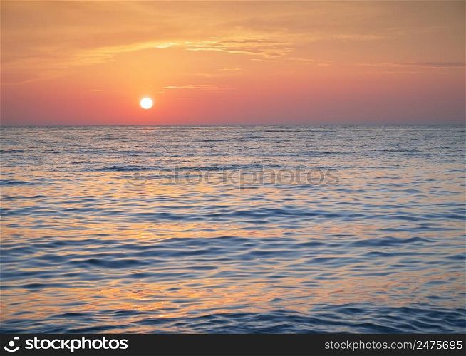 Bright sunset with yellow sun. Nature seascape.